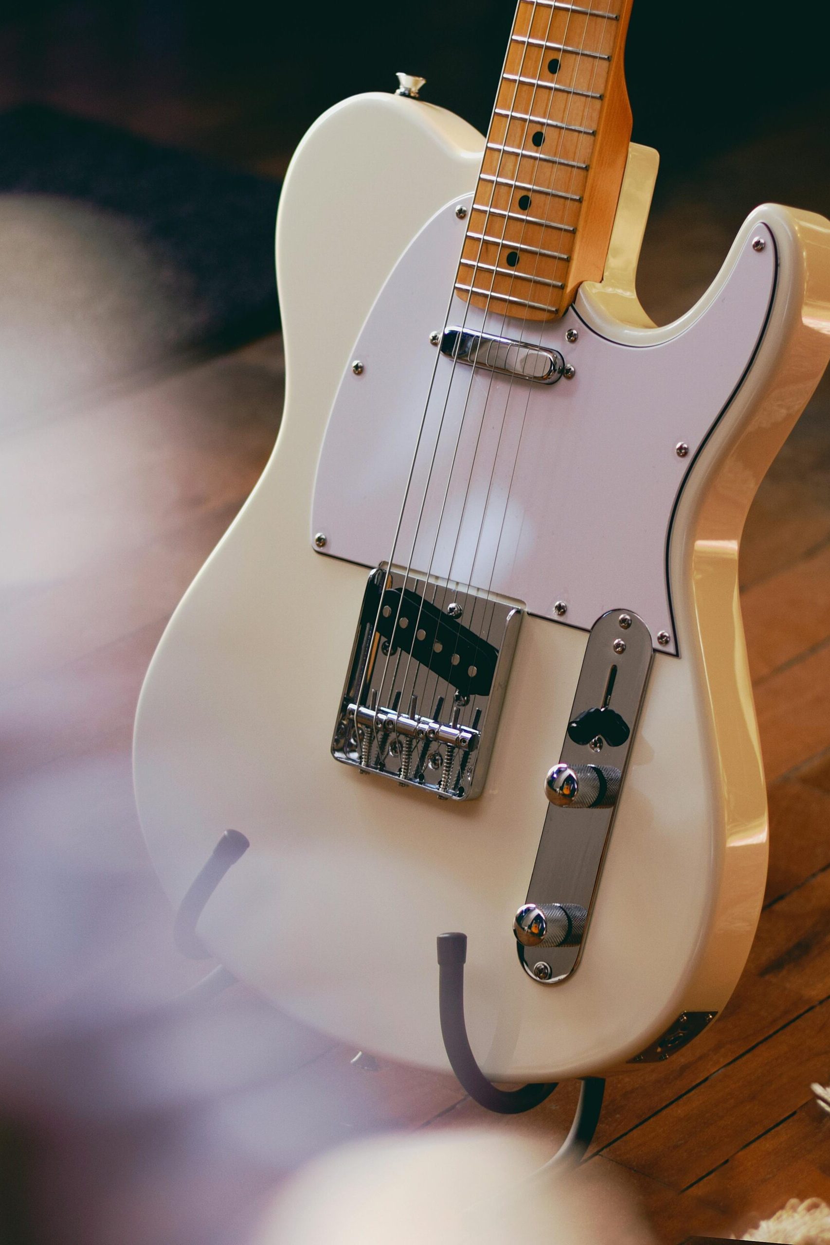 A detailed view of a vintage electric guitar resting on a wooden floor, showcasing classic design.